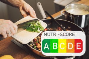 Une personne prépare de la nourriture dans une poêle à frire avec le mot nutri-score abc.