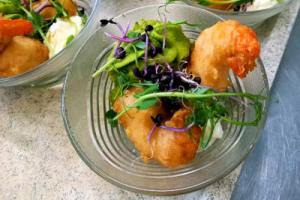 Crevettes et légumes dans des bols en verre sur un comptoir.