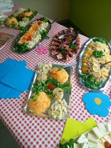 Une table pleine de nourriture sur une nappe à carreaux.