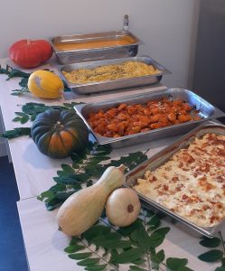 Une table pleine de plats avec des citrouilles et des courges.